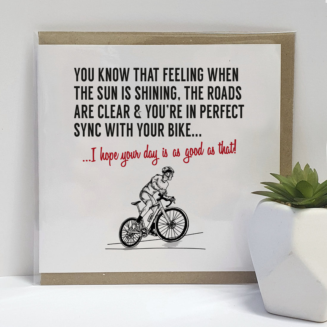 Greeting card featuring a black and white illustration of a cyclist on a clear day, with the text 'You know that feeling when the sun is shining, the roads are clear & you're in perfect sync with your bike... I hope your day is as good as that!'