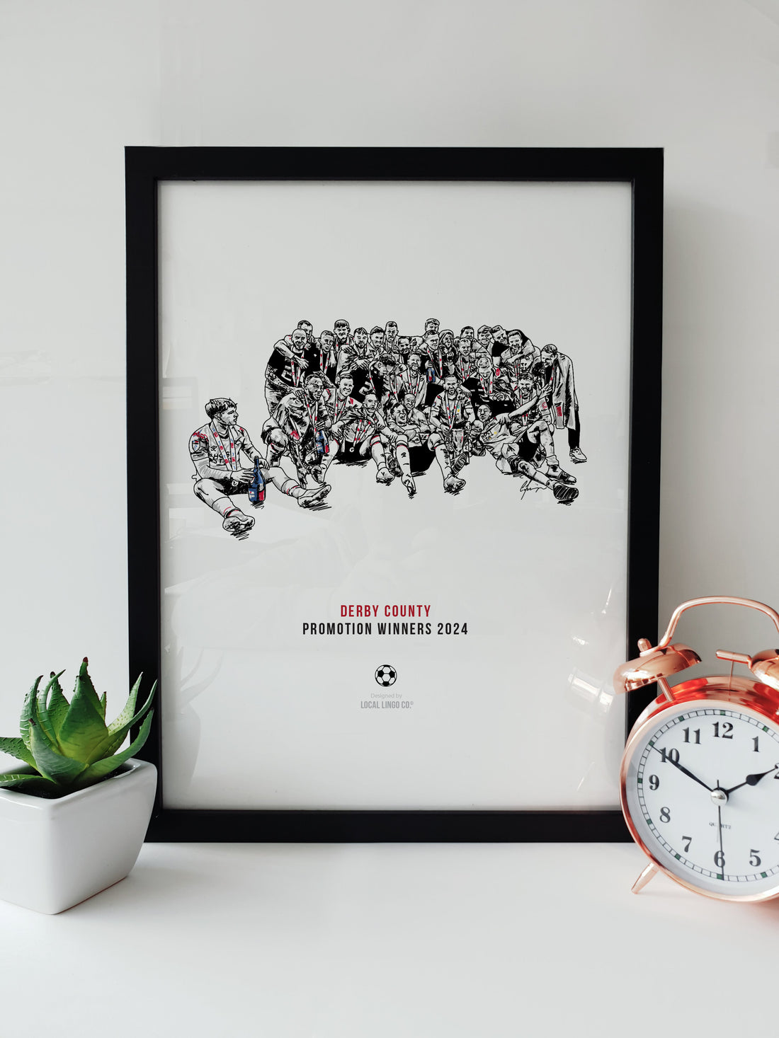 Black and white print of Derby County's football team celebrating their 2024 promotion, with players joyously gathered in a group on the field. designed by local lingo