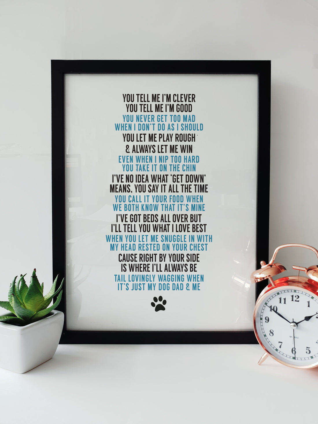 Framed print with a heartfelt poem for a dog dad, perfect for Father's Day or any occasion, displayed on a white desk next to a plant and a copper alarm clock. DESIGNED BY LOCAL LINGO