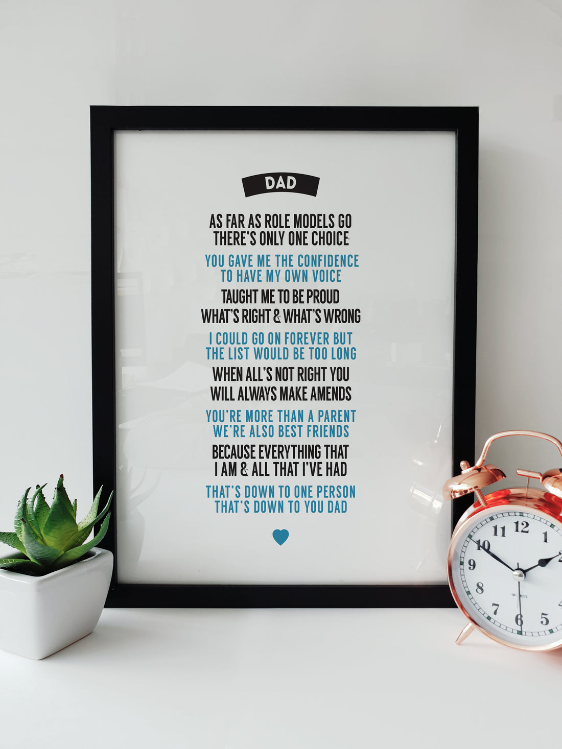 Framed print with a heartfelt poem for Dad, perfect for Father's Day or any occasion, displayed on a white desk next to a plant and a copper alarm clock DESIGNED BY LOCAL LINGO