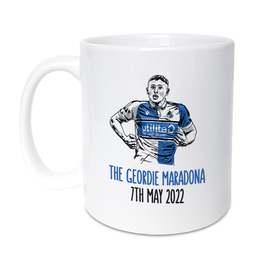 A unique mug which will make the perfect gift for any Bristol Rovers supporter. Featuring hand drawn illustration of Elliot Anderson   Mug reads:  the Geordie Maradona 7th May 2022