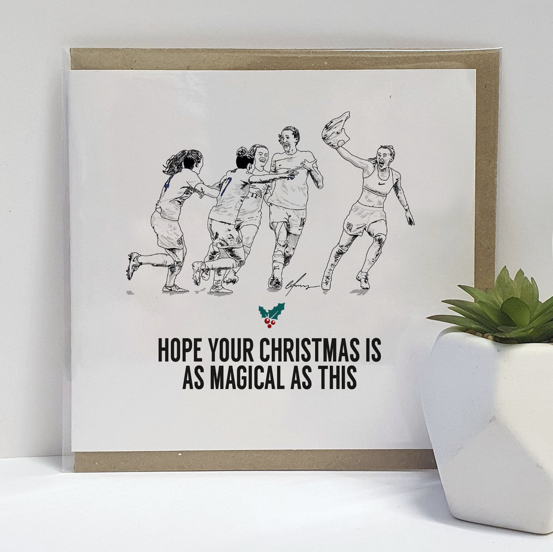 England Women Euro Winners Christmas card. Card reads:  I hope your Christmas is as magical as that (Featuring an illustration of the England women's national football team celebrating, Chloe Kelly's famous celebration after scoring & popular plays such as Jill Scott, Lauren Hemp & Keira Walsh).