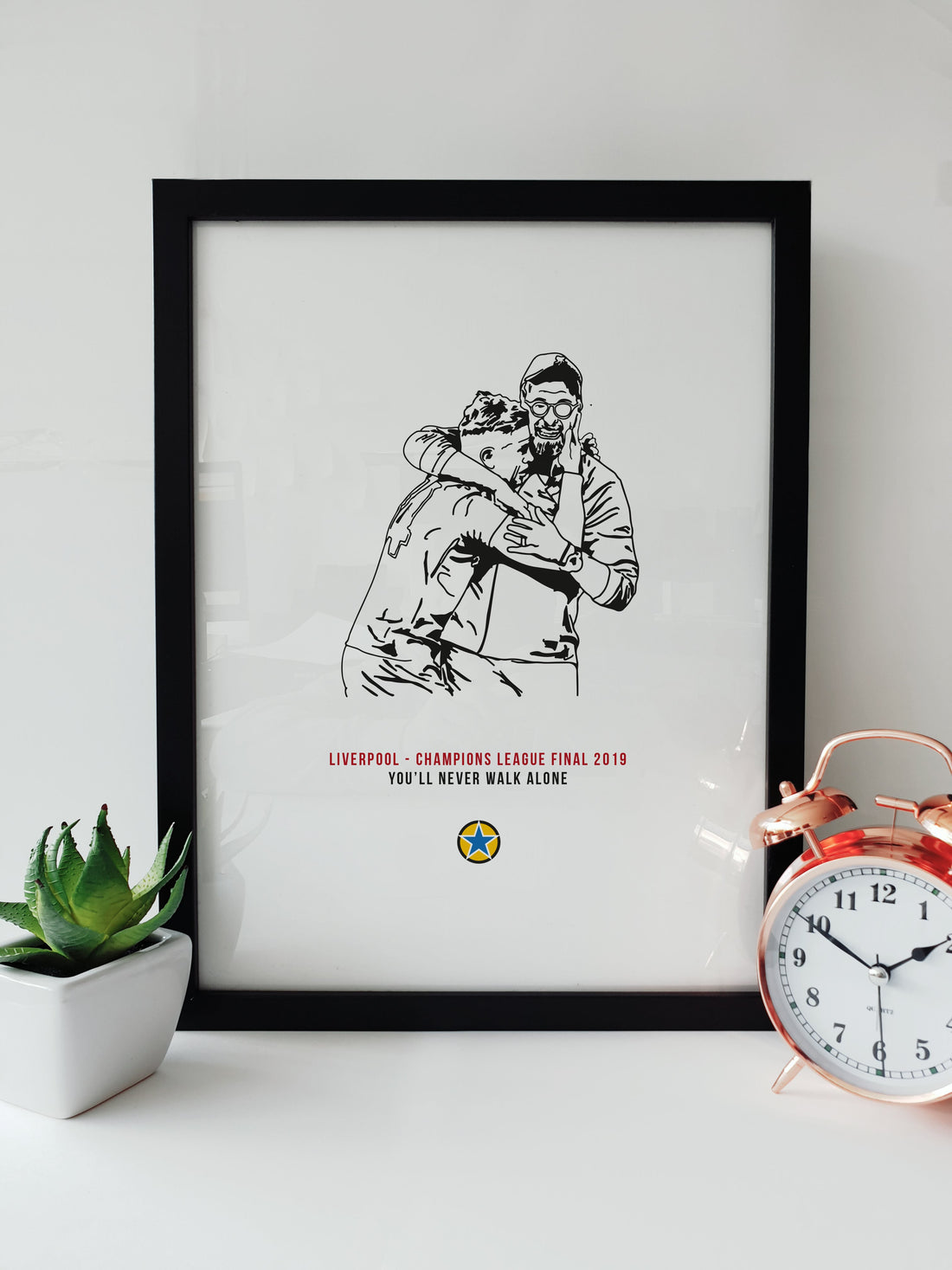 A unique Liverpool themed print which features a hand drawn illustrations of Jurgen Klopp & Jordan Henderson embracing after Liverpool won their 6th Champions League title in 2019.   Print reads:  Liverpool - Champions League Final 2019 - You'll never walk alone.